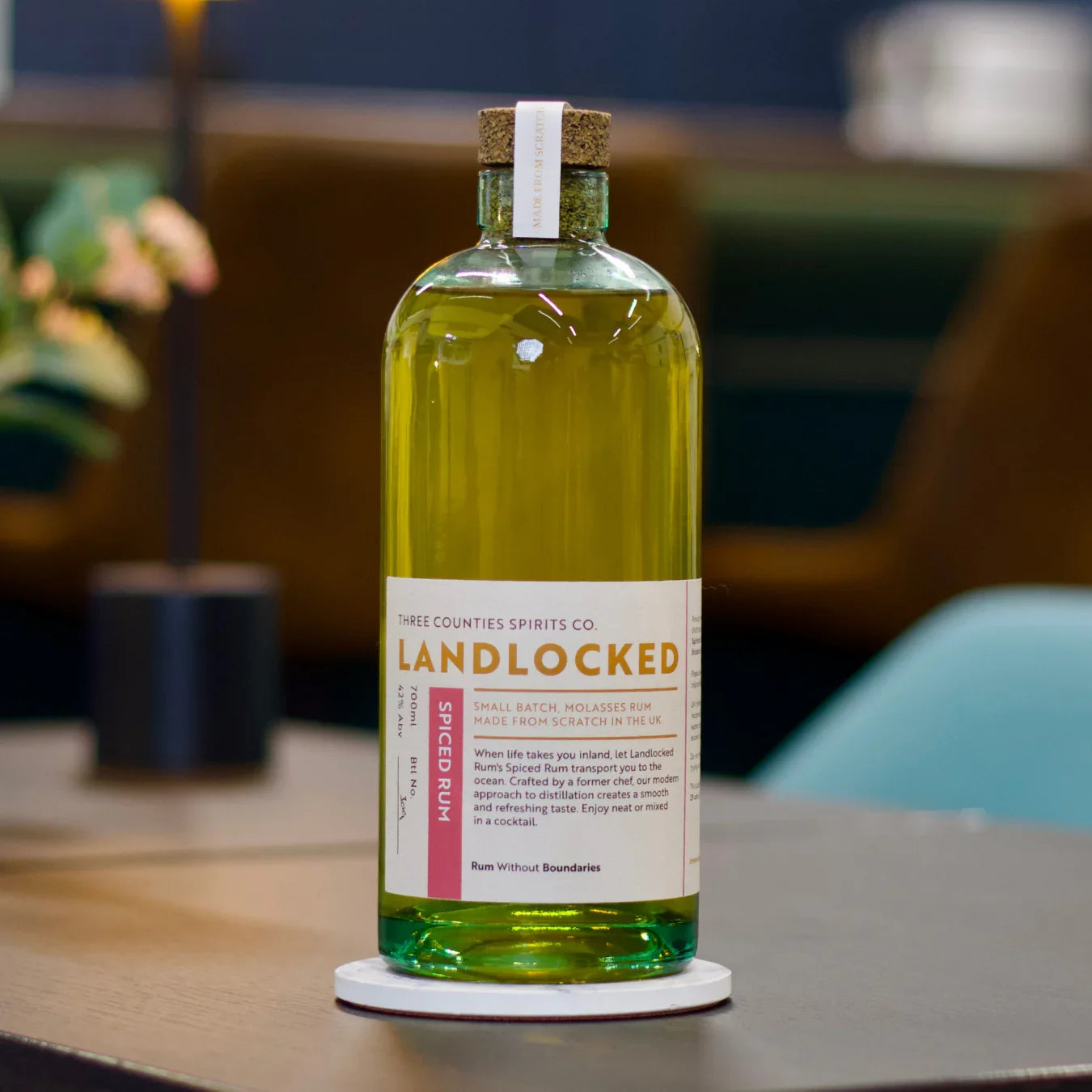Bottle of Landlocked spiced rum by Three Counties Spirits Co. on a table with blurred background