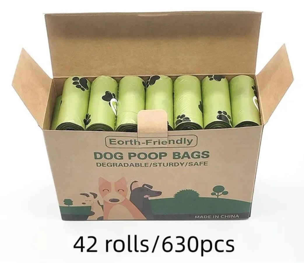 Open box of earth-friendly degradable dog poop bags with green rolls and paw prints, 42 rolls 630 pcs